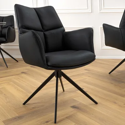 A black leather chair with a metal base on a wooden floor.