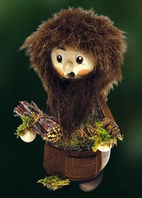 Moosmännel hat freundliches Gesicht mit großen Augen und einer kleinen Nase, dichte, braune, Haare.