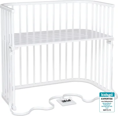 A white baby crib with a mattress support.
