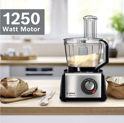 A Bosch food processor is shown on a kitchen counter with bread and flour.