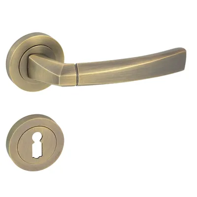 A door handle set with a keyhole escutcheon plate, both in a bronze finish, isolated on a white background.