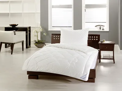 A bedroom scene with a bed, nightstand, and chair.