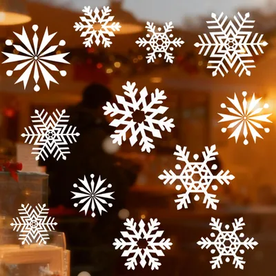 Snowflake window stickers are displayed on a window with a blurred background of a store interior.