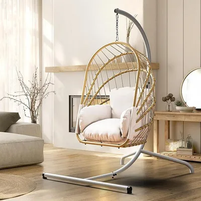 Imagen del producto de Silla colgante color beige, con estructura, y cesta de ratán. Silla mecedora con acolchado resistente, capacidad de carga de 160 kg, ideal para jardín, dormitorio, balcón, uso en exteriores o interiores