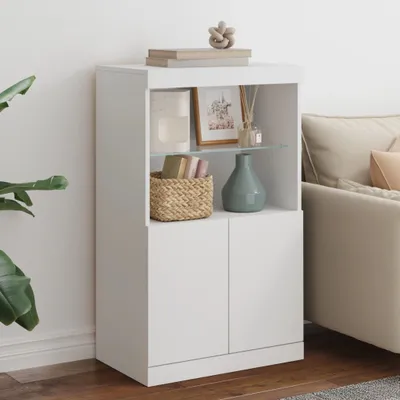 A white cabinet with shelves, decorated with books, a picture frame, a vase, and a basket, placed next to a sofa.