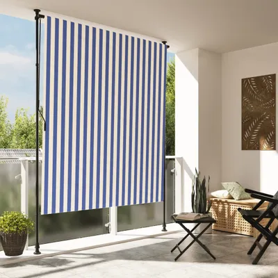 A balcony with a striped outdoor roller blind, furniture, and plants.