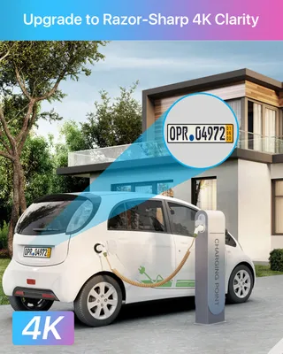 An electric car is charging in front of a modern house, with a close-up of a license plate highlighted.
