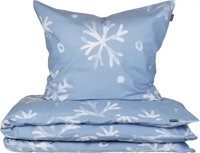 A folded duvet and pillow with a snowflake print on a white background.