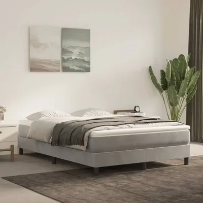 A bedroom scene with a bed, artwork, and a plant.