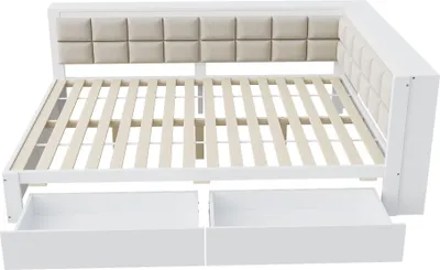 A white bed frame with a beige upholstered headboard and two open drawers underneath.