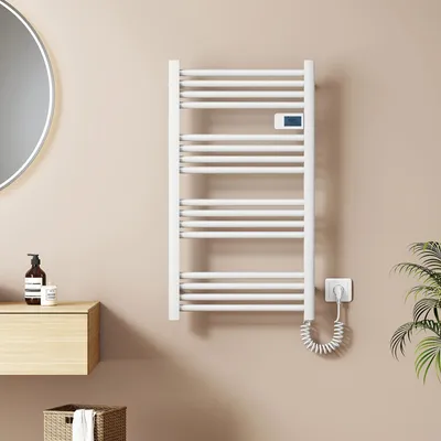 A white electric towel warmer is mounted on a light beige wall in a bathroom setting.