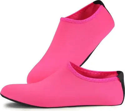 Paar leuchtend pinke Wasserschuhe mit schwarzen Sohlen, einer aufrecht stehend und einer flach liegend