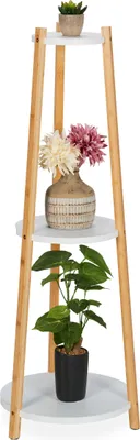 A three-tiered plant stand with decorative items on each shelf.