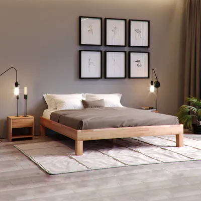 A bedroom scene with a wooden bed frame, bedding, nightstand, lamp, and artwork on the wall.