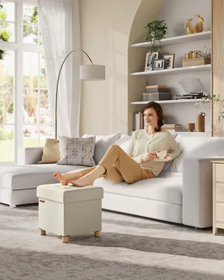 A woman relaxes on a sofa, with her feet on an ottoman.