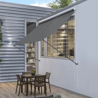 An outdoor patio with a table and chairs under a gray awning.