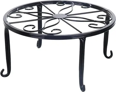 A black metal plant stand with a round top and four legs.