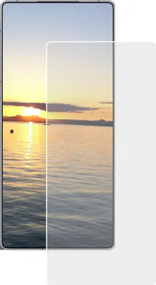 A screen protector is shown on top of a smartphone displaying a sunset over water.