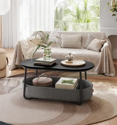 A modern living room scene featuring a coffee table with storage, a sofa, and a rug.