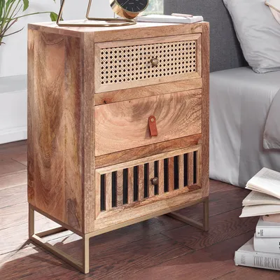 A wooden nightstand with three drawers is placed next to a bed.