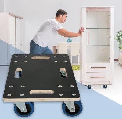 A man is pushing a tall cabinet with a furniture dolly in front of it.