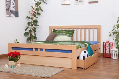 A bedroom setting with a wooden bed frame, bedding, and decorative items.