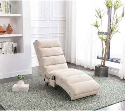 A beige chaise lounge in a living room setting with a bookshelf and a plant.