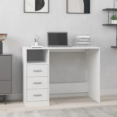 A white desk with drawers and a laptop on it, placed in a room with artwork on the wall.