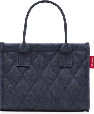 A studio product shot of a dark blue quilted shopper bag.
