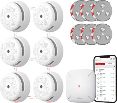 A collection of smart smoke detectors, a base station, and a smartphone displaying the app interface, all arranged on a white background.