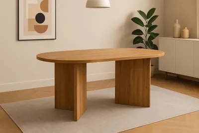 A wooden oval dining table is shown in a well-lit room with a rug underneath and a piece of abstract art on the wall.