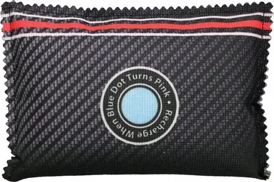 A desiccant packet with a carbon fiber-like texture and a circular indicator.
