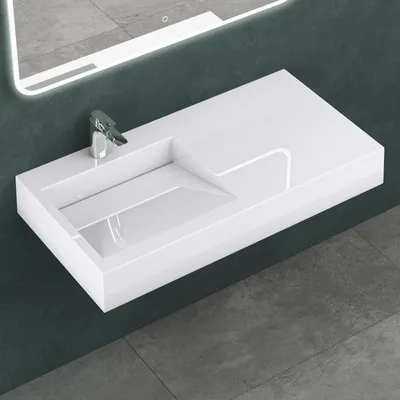 A white rectangular wall-mounted sink with a chrome faucet is shown against a dark gray wall and a gray tiled floor.