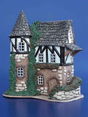 Ein Heidehof mit Fachwerk einem steilen Schindeldach, das an mittelalterliche Architektur erinnert.
