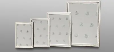 Four silver picture frames of varying sizes arranged in a row.