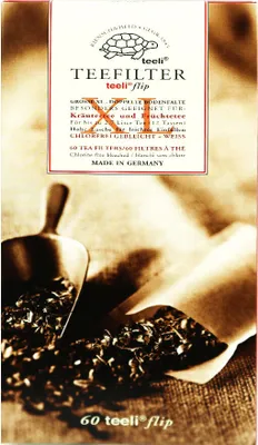 A close-up image of a box of tea filters with tea leaves scattered in the foreground.