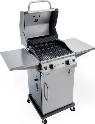 A stainless steel gas grill with the lid open, showing the cooking grates and warming rack. It is on a wheeled cart with side shelves.