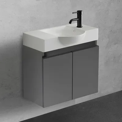 A modern wall-mounted bathroom vanity with a sink and faucet against a textured gray wall.