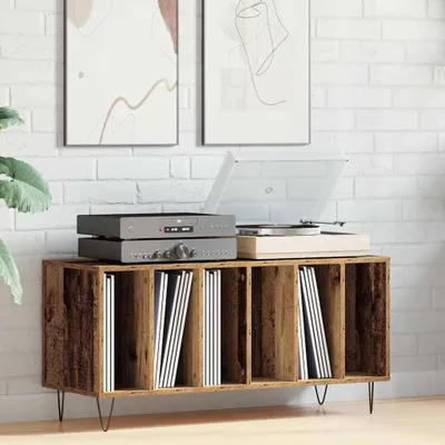 A record player and audio equipment are displayed on top of a wooden cabinet filled with records, set against a white brick wall.