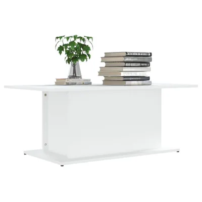 A white coffee table with books and a plant on top, set against a white background.