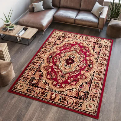 A Persian-style rug is placed on a wooden floor in a living room, next to a leather sectional sofa and a coffee table.