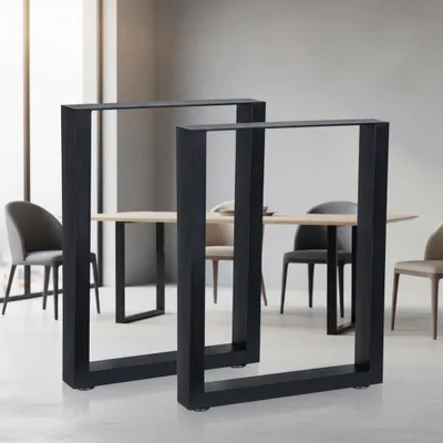 Two black metal table legs are shown in a dining room setting with a wooden table and chairs.