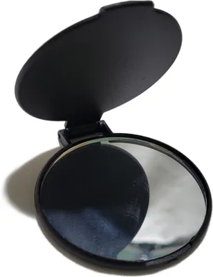 A black, round cosmetic mirror with its lid open, shown against a white background.