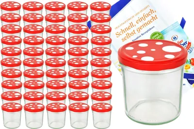 A collection of small glass jars with red and white mushroom-shaped lids, along with a recipe booklet, are displayed against a white background.