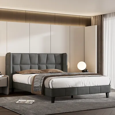 A modern bedroom with a gray upholstered bed and a side table.