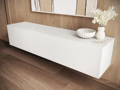 A white floating TV cabinet with decorative items on top, set against a wood-paneled wall and wooden floor.