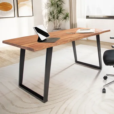 A wooden desk with black metal U-shaped legs in a home office setting.
