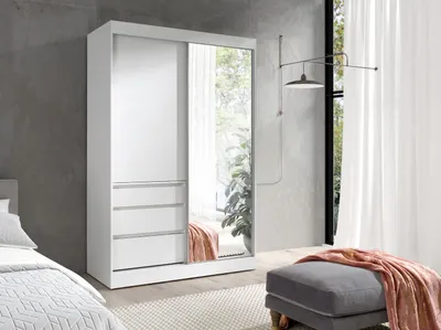 A modern bedroom with a white wardrobe with mirrored doors and drawers, a grey ottoman with a pink throw, and a bed in the foreground.