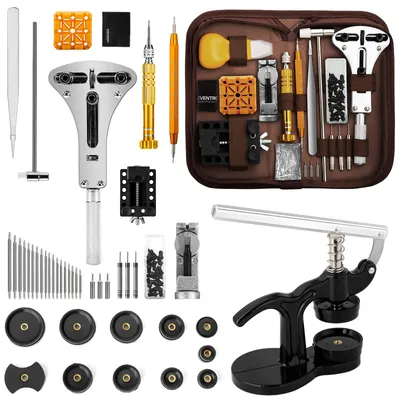 A collection of watch repair tools laid out on a white background, with a brown case containing some of the tools.
