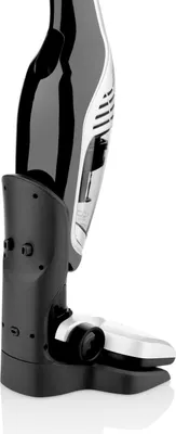 A close-up, side view of a black and silver handheld vacuum cleaner docked in its charging base against a white background.
